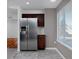 Bright kitchen showcasing stainless steel refrigerator, stylish tile floors, and natural light from a window at 9436 Cody Dr, Broomfield, CO 80021