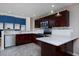 Modern kitchen with dark wood cabinets, quartz countertops, stainless steel appliances, and mosaic backsplash at 9436 Cody Dr, Broomfield, CO 80021