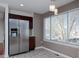 Eat-in kitchen featuring a stainless steel refrigerator, dark wood cabinets, and a bright window at 9436 Cody Dr, Broomfield, CO 80021