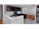 Modern kitchen with dark wood cabinets, quartz countertops and stainless steel appliances open to dining area at 9436 Cody Dr, Broomfield, CO 80021