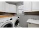 Functional laundry room boasts modern washer and dryer, storage cabinets, and a sink area at 9436 Cody Dr, Broomfield, CO 80021