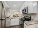 Modern kitchen with stainless steel appliances, granite countertops, and white cabinets at 2239 S Jasper Way # A, Aurora, CO 80013