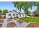 Charming home featuring a large backyard with a garden, lush lawn, and playset at 6537 Everett St, Arvada, CO 80004
