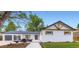 Charming exterior with white brick, modern dark trim, 2 car garage and inviting front patio at 6537 Everett St, Arvada, CO 80004
