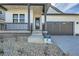 Close-up of a home's front entrance and covered porch with black pillars and a two-car garage to the side at 2750 E 102Nd Pl, Thornton, CO 80229