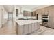 A modern kitchen features custom cabinetry, stainless steel appliances, a large island, and plenty of room to entertain at 2750 E 102Nd Pl, Thornton, CO 80229