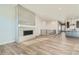 An open concept living area with a sleek fireplace feature, hardwood floors, and seamlessly connected kitchen at 2750 E 102Nd Pl, Thornton, CO 80229