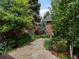 Lush backyard featuring a stone patio, mature trees, and manicured landscaping at 405 S University Blvd, Denver, CO 80209