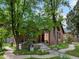 Quaint brick home featuring an inviting porch, mature trees, and a well-manicured lawn, emphasizing curb appeal at 405 S University Blvd, Denver, CO 80209