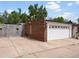 Detached two-car garage with white door and adjacent brick and concrete walls at 405 S University Blvd, Denver, CO 80209