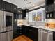 The modern kitchen has stainless steel appliances and black cabinets at 405 S University Blvd, Denver, CO 80209