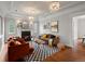Stylish living room featuring a cozy fireplace, elegant chandeliers, and hardwood floors, creating a warm ambiance at 405 S University Blvd, Denver, CO 80209