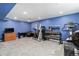 Finished basement with fitness equipment and blue walls at 12418 Albion St, Thornton, CO 80241