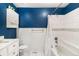Bright bathroom features white tile, blue accent wall, and updated vanity with plenty of storage at 12418 Albion St, Thornton, CO 80241