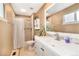 This bathroom features a vanity, sink, mirror, tile flooring, and a shower with a curtain at 12418 Albion St, Thornton, CO 80241