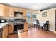 Sunlit kitchen features wood cabinets, stainless steel appliances, and a dining area with natural lighting at 12418 Albion St, Thornton, CO 80241