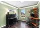 A well-lit home office features a piano, desk, and shelving unit, with hardwood floors at 12418 Albion St, Thornton, CO 80241