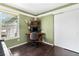 A well-lit home office features a desk, shelving unit, and hardwood floors at 12418 Albion St, Thornton, CO 80241