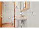 Powder room featuring pedestal sink, neutral color palette and framed mirror at 8280 Queen St, Arvada, CO 80005