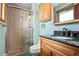 Bathroom features a glass enclosed shower, wood vanity with granite countertop and tile floors at 8280 Queen St, Arvada, CO 80005