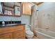 Bathroom with wood cabinets and trim, granite vanity, shower and bath with tile surround at 8280 Queen St, Arvada, CO 80005