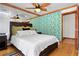 Bedroom with wood floors, ceiling fan, queen size bed and closet with green and white wall paper at 8280 Queen St, Arvada, CO 80005