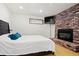 Bedroom with brick fireplace, mounted television, window with privacy glass and hardwood floors at 8280 Queen St, Arvada, CO 80005