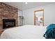 Bedroom with white walls, gas fireplace and brick surround, carpet in adjoining sitting room at 8280 Queen St, Arvada, CO 80005