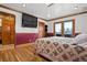 Bedroom with wood floors and trim, flat screen television, and French doors to balcony at 8280 Queen St, Arvada, CO 80005