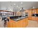 Expansive kitchen island featuring black granite countertop with stylish cabinetry and stainless steel range hood at 8280 Queen St, Arvada, CO 80005