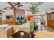 Open living space with wood beam ceilings, brick accents, and indoor plants creating a nature-filled ambiance at 8280 Queen St, Arvada, CO 80005