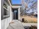 View of the home's front entry with a black front door and a well-manicured lawn at 2645 Jasmine St, Denver, CO 80207