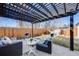 Backyard patio featuring modern outdoor furniture, black pergola, and grill at 2645 Jasmine St, Denver, CO 80207