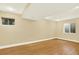 Bright basement showcasing wood-look flooring, neutral paint, and a pair of window wells at 2246 Mountain Sage Dr, Highlands Ranch, CO 80126