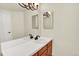 Bathroom with double sinks, wood cabinets, updated lighting, and a large mirror at 2246 Mountain Sage Dr, Highlands Ranch, CO 80126