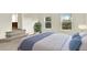 Bright bedroom features plush carpeting, a large bed, and two sunny windows with views of the surrounding greenery at 2246 Mountain Sage Dr, Highlands Ranch, CO 80126