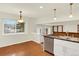 Inviting dining area with views, modern light fixtures and a stainless steel dishwasher at 2246 Mountain Sage Dr, Highlands Ranch, CO 80126