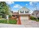 Traditional two-story home featuring a two-car garage, landscaped front yard, and brick walkway on a sunny day at 2246 Mountain Sage Dr, Highlands Ranch, CO 80126