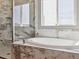 Elegant bathroom featuring marble countertops, a soaking tub, and a glass enclosed shower with shelving at 11426 Box Turtle Ct, Parker, CO 80134
