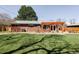 Expansive backyard with a lush lawn, brick home, pergola, and ample space for outdoor activities and relaxation at 3130 S Krameria St, Denver, CO 80222