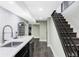Basement bar area with quartz countertops, stainless sink and black appliances at 3130 S Krameria St, Denver, CO 80222
