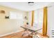 Bright home office with hardwood floors, large window, and complementary golden colored curtains at 3130 S Krameria St, Denver, CO 80222