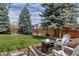 Fenced backyard with a green lawn, a fire pit, and a trampoline at 10046 Brisbane Ln, Highlands Ranch, CO 80130