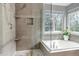 Bathroom featuring a tiled walk-in shower with rainfall shower head and a soaking tub with a view at 10046 Brisbane Ln, Highlands Ranch, CO 80130