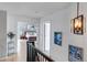 Hallway with hardwood floors, art, and views into the main bedroom at 10046 Brisbane Ln, Highlands Ranch, CO 80130