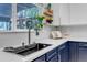 Modern kitchen featuring stainless steel sink, white subway tiles, floating wood shelves, and a large window at 10046 Brisbane Ln, Highlands Ranch, CO 80130