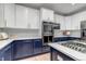 Bright kitchen featuring white upper cabinets, navy blue lower cabinets, stainless steel appliances and gas cooktop at 10046 Brisbane Ln, Highlands Ranch, CO 80130
