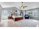 Light-filled primary bedroom featuring vaulted ceiling, hardwood floors, a ceiling fan and a sitting area at 10046 Brisbane Ln, Highlands Ranch, CO 80130