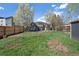 Spacious backyard with wooden fence and mature trees, providing privacy and natural beauty to the property at 1601 Robb St, Lakewood, CO 80215