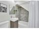 Small bathroom features tiled shower/tub, mountain art, modern vanity at 1601 Robb St, Lakewood, CO 80215
